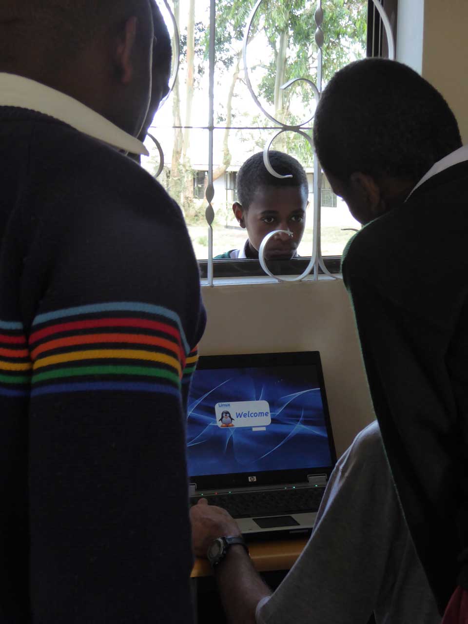 Curious young student looking in at others working in lab